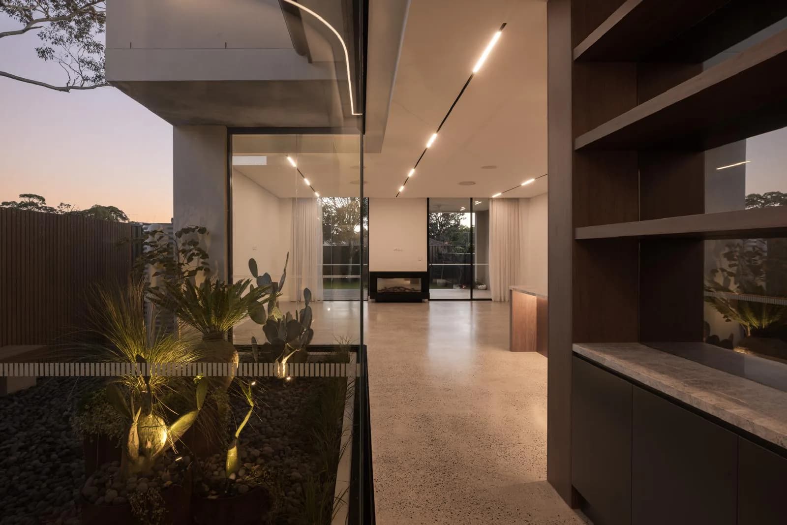 Ian Duplex internal courtyard connecting concrete, glazing, planting, and the adjoining living spaces